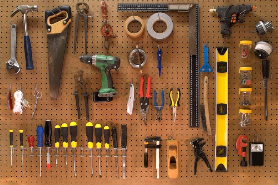 Pegboard wall organized with a variety of hand tools for DIY work