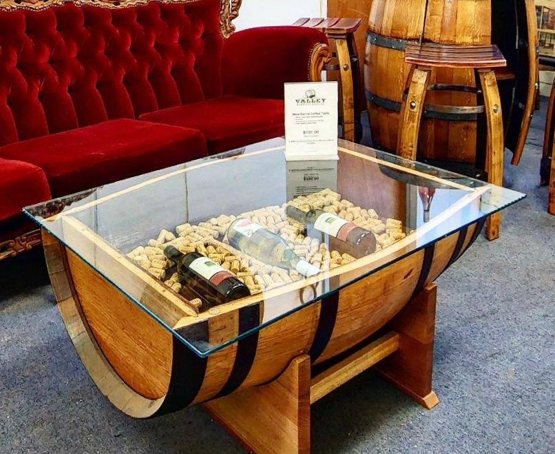 Glass-top coffee table made from a wine barrel filled with corks and bottles