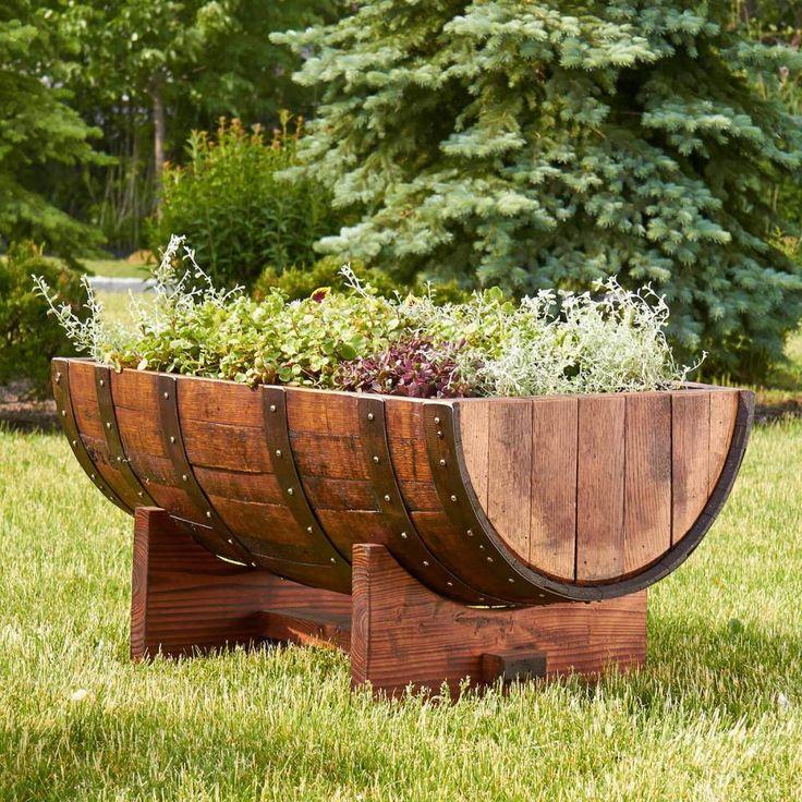 A wooden half-barrel planter filled with various garden plants