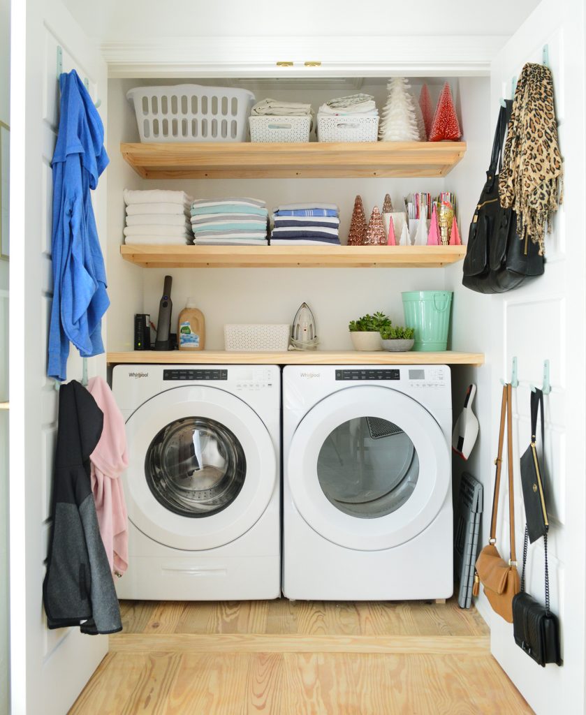 A laundry room, with shelving above the washer-dryer set storing laundry materials.