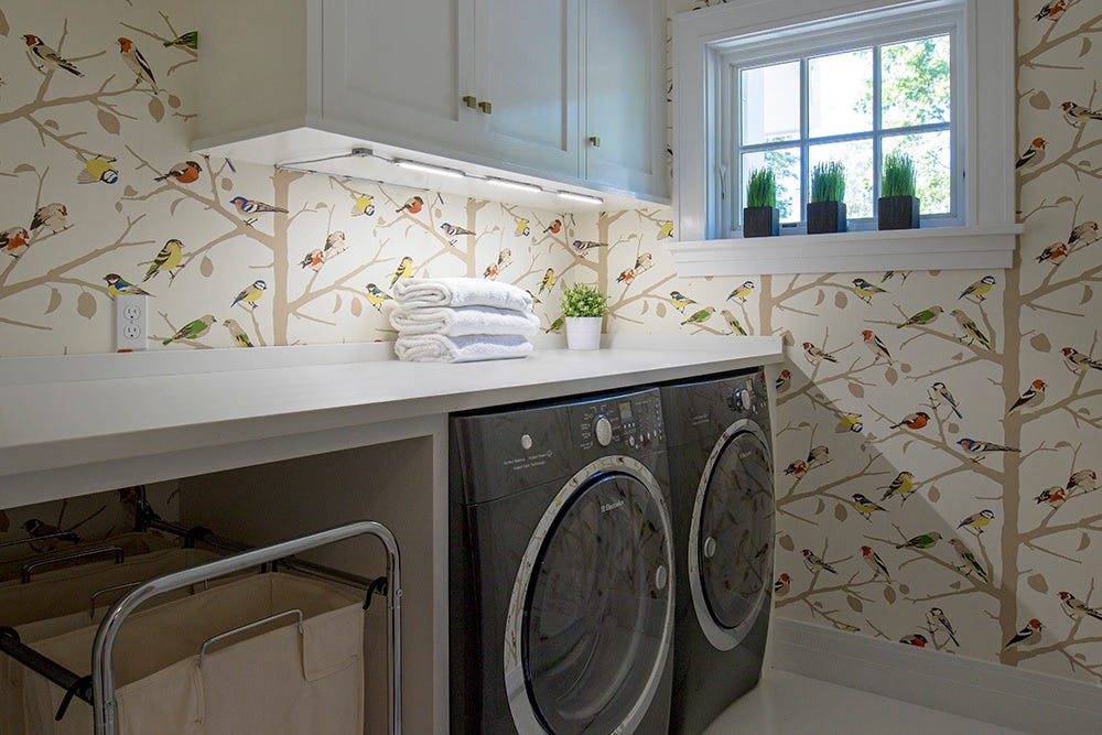 Lights under a cabinet about the washer-dryer countertop shelf.