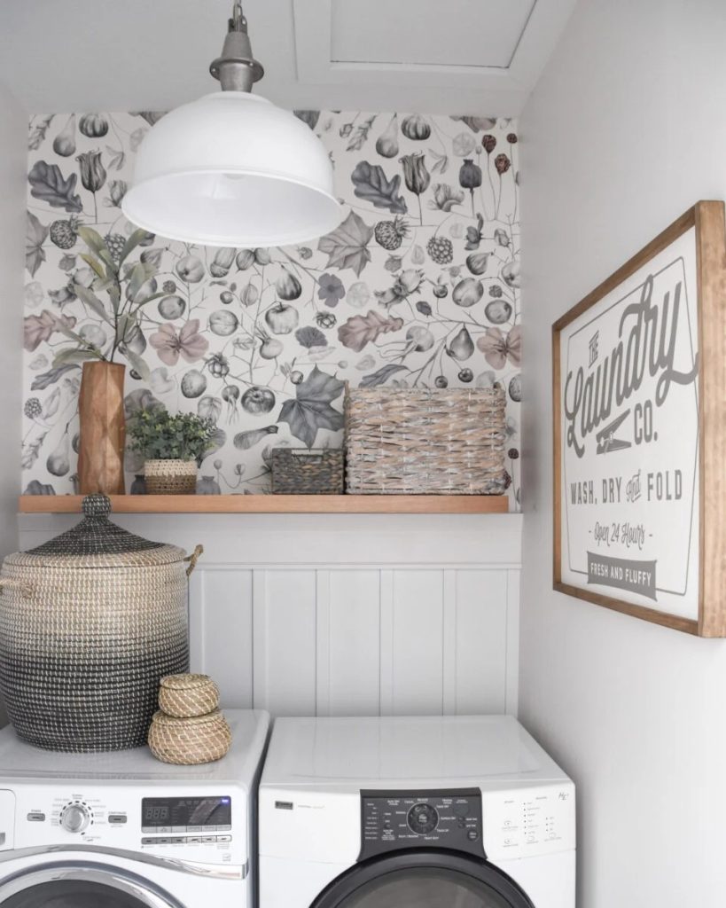A laundry room with an accessible wallpaper behind the washer-dryer set.