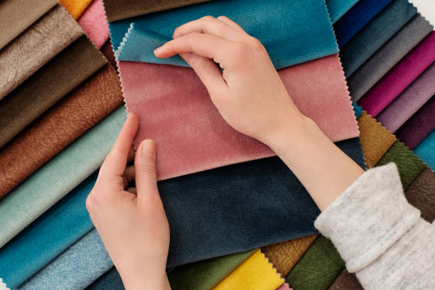 Hands browsing colorful textile swatches for design