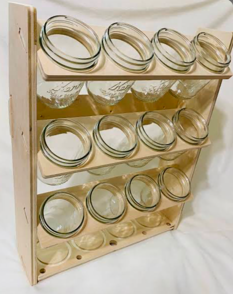 Glass jar storage rack with multiple jars in a wooden frame.