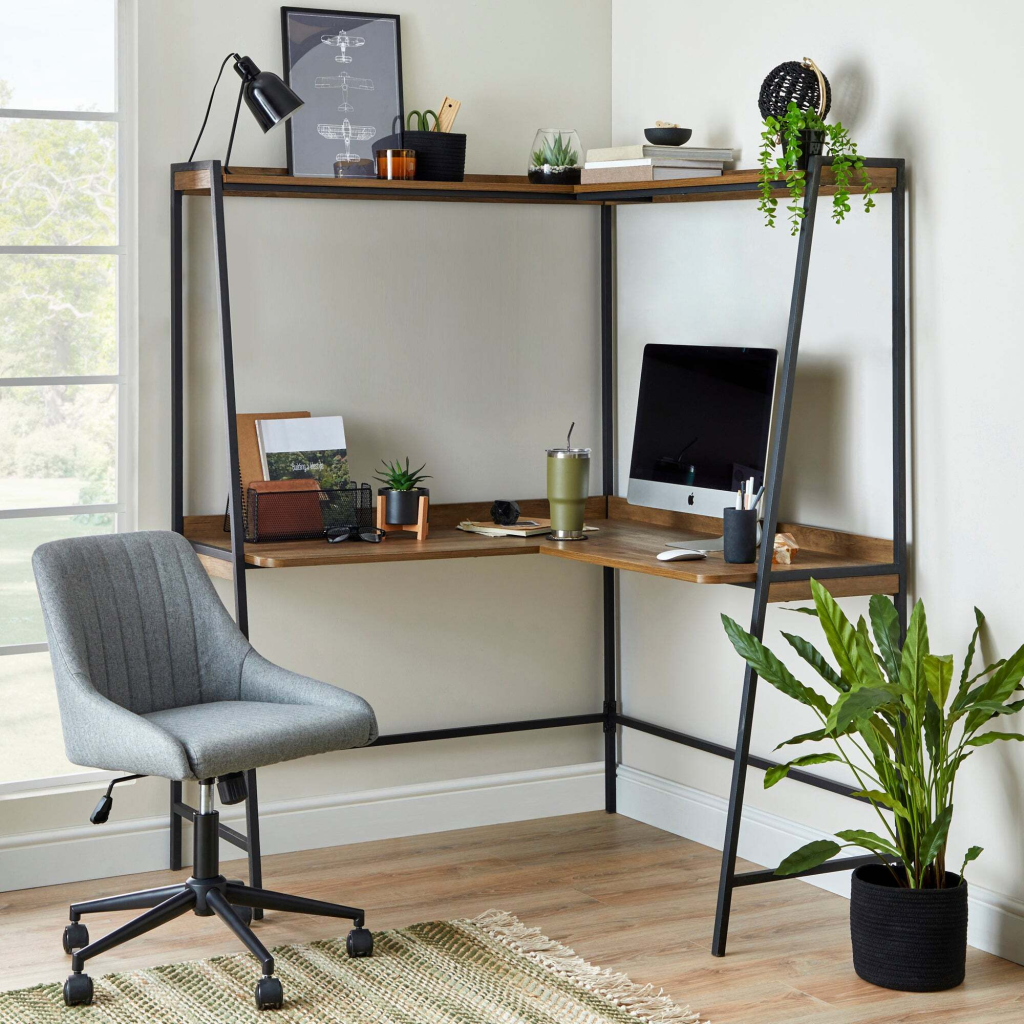 Corner home office setup with a wooden desk and grey chair near a large window