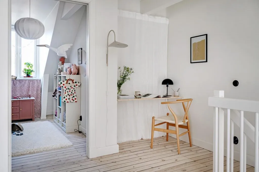 Minimalist workspace with white curtain partition and natural wood desk