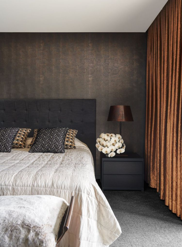 Elegant bedroom with textured brown walls and copper curtains.
