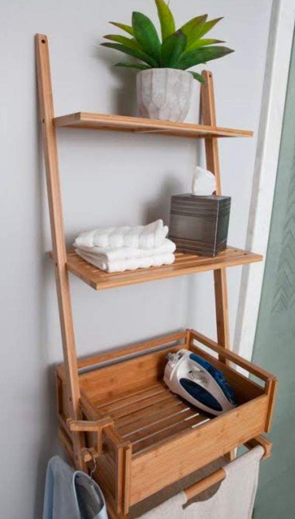 Wall-mounted wooden laundry shelf with plants and towels