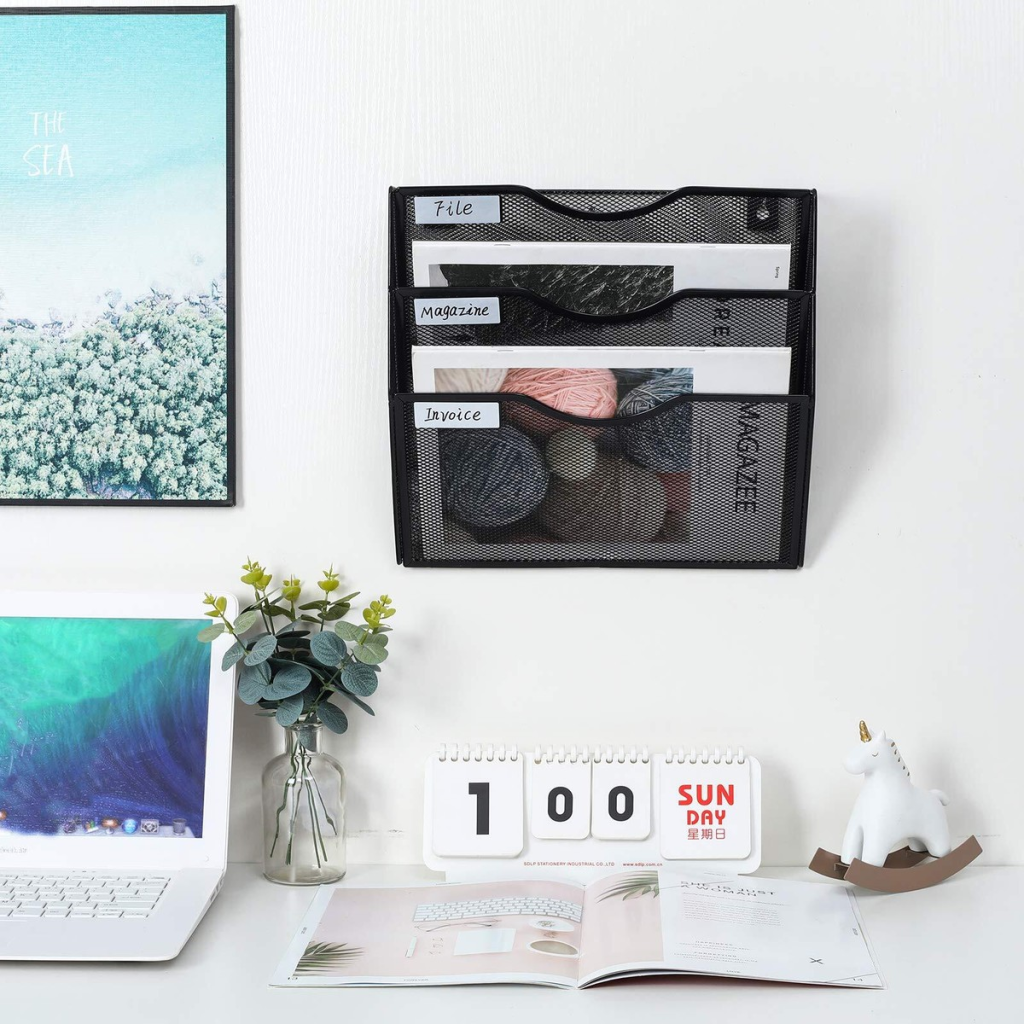 Minimalist desk setup with wall-mounted file organizer and decorative items