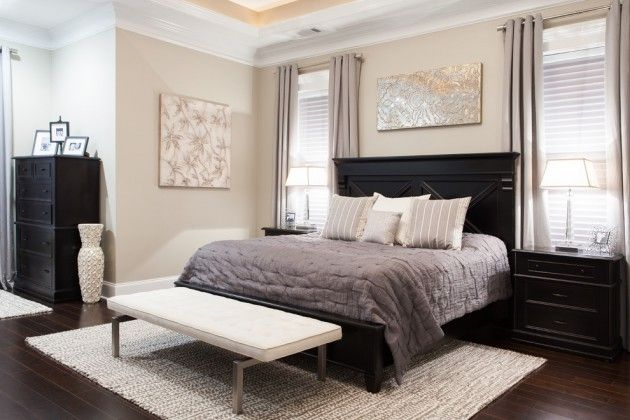 Bedroom with dark furniture and gray bedding, modern decor.
