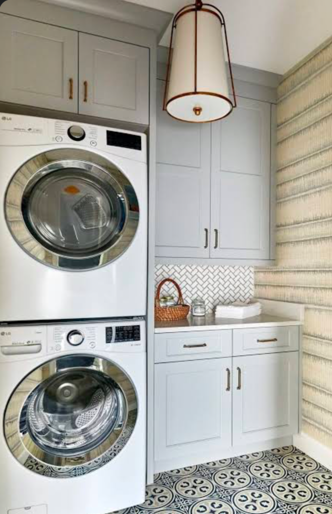 Compact laundry room with stacked washer dryer and patterned floor tiles