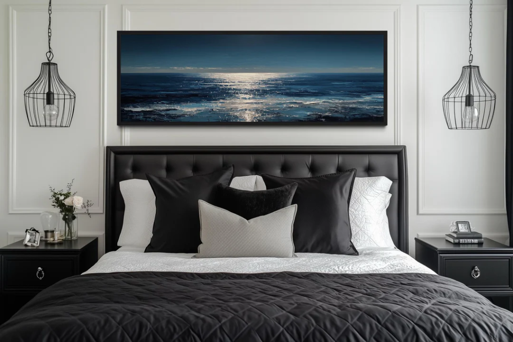 Black and white bedroom with ocean artwork above the bed.