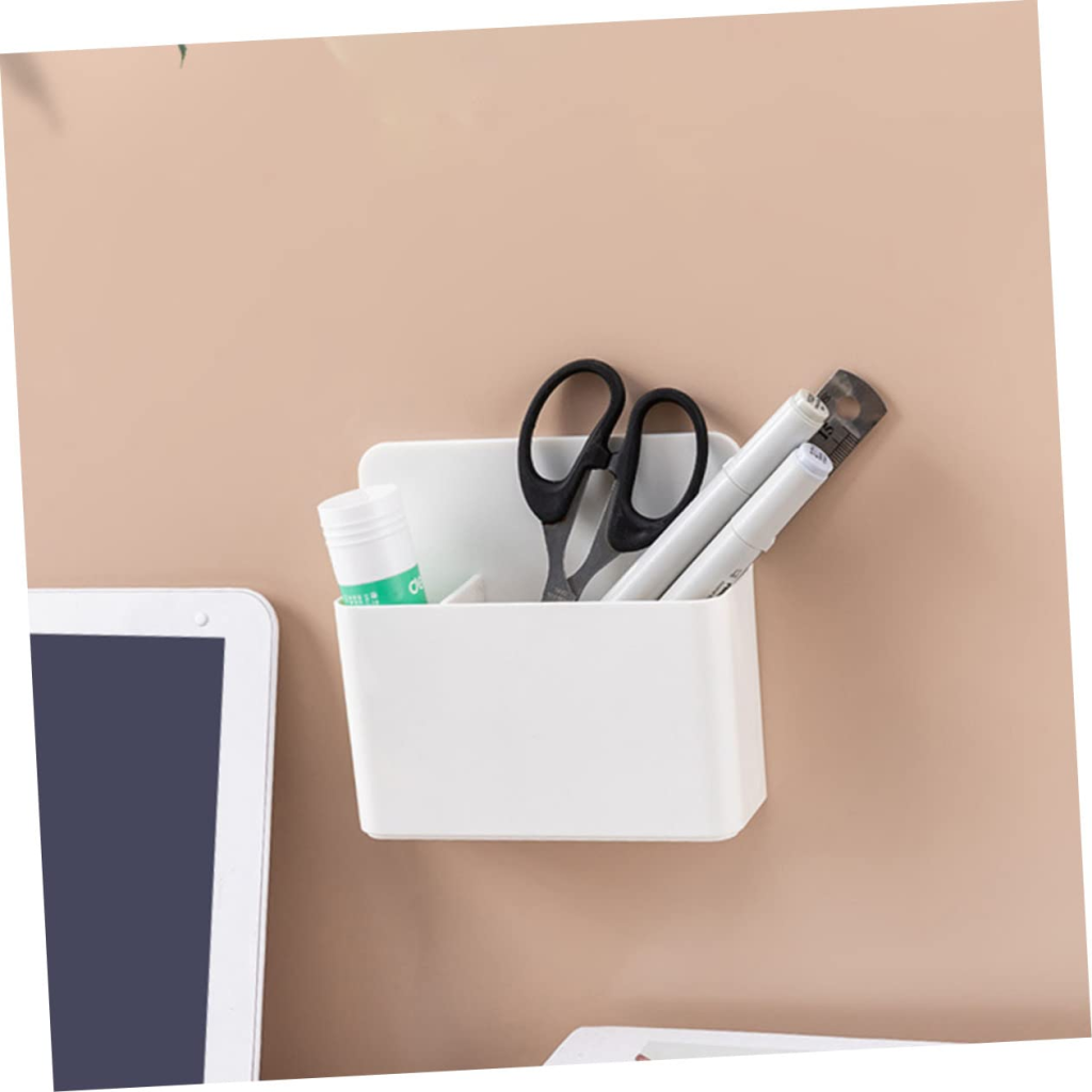 Wall-mounted white pen holder with scissors, markers, and glue stick.
