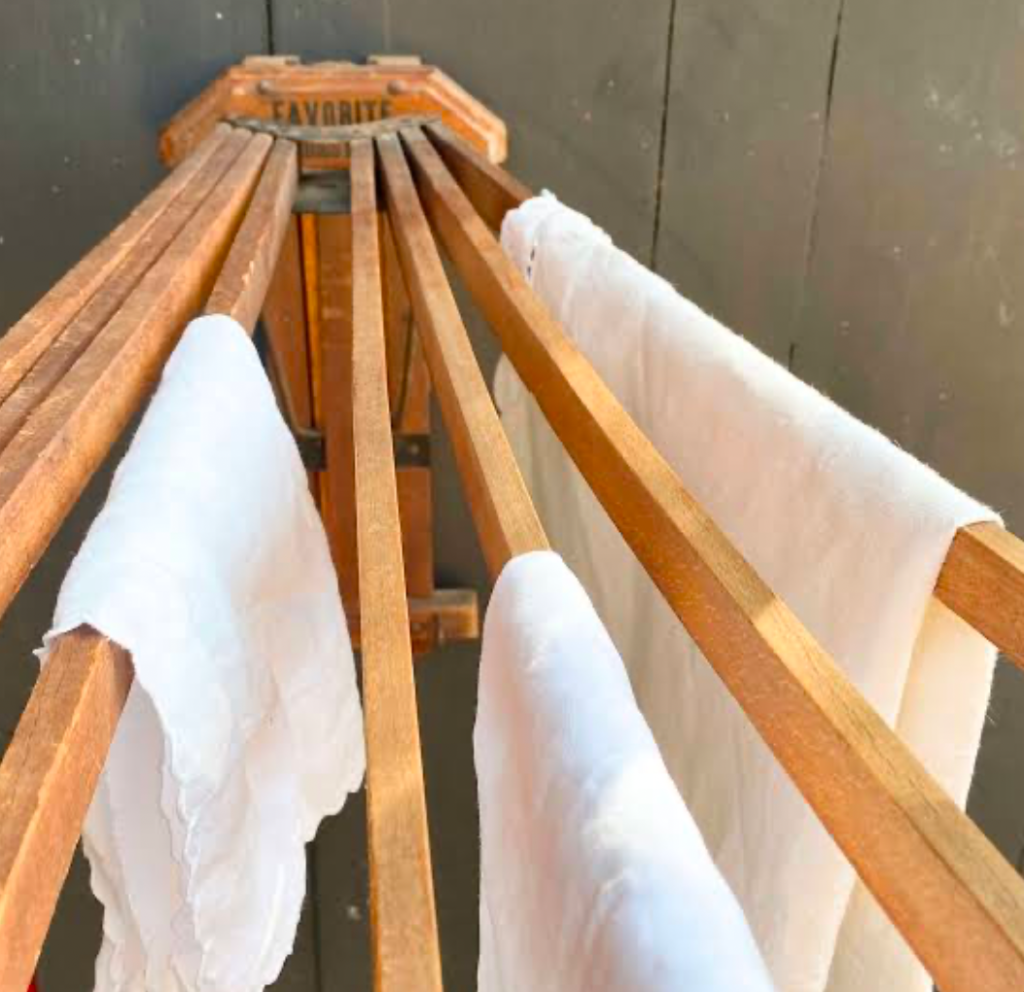 Wooden clothes drying rack with white towels