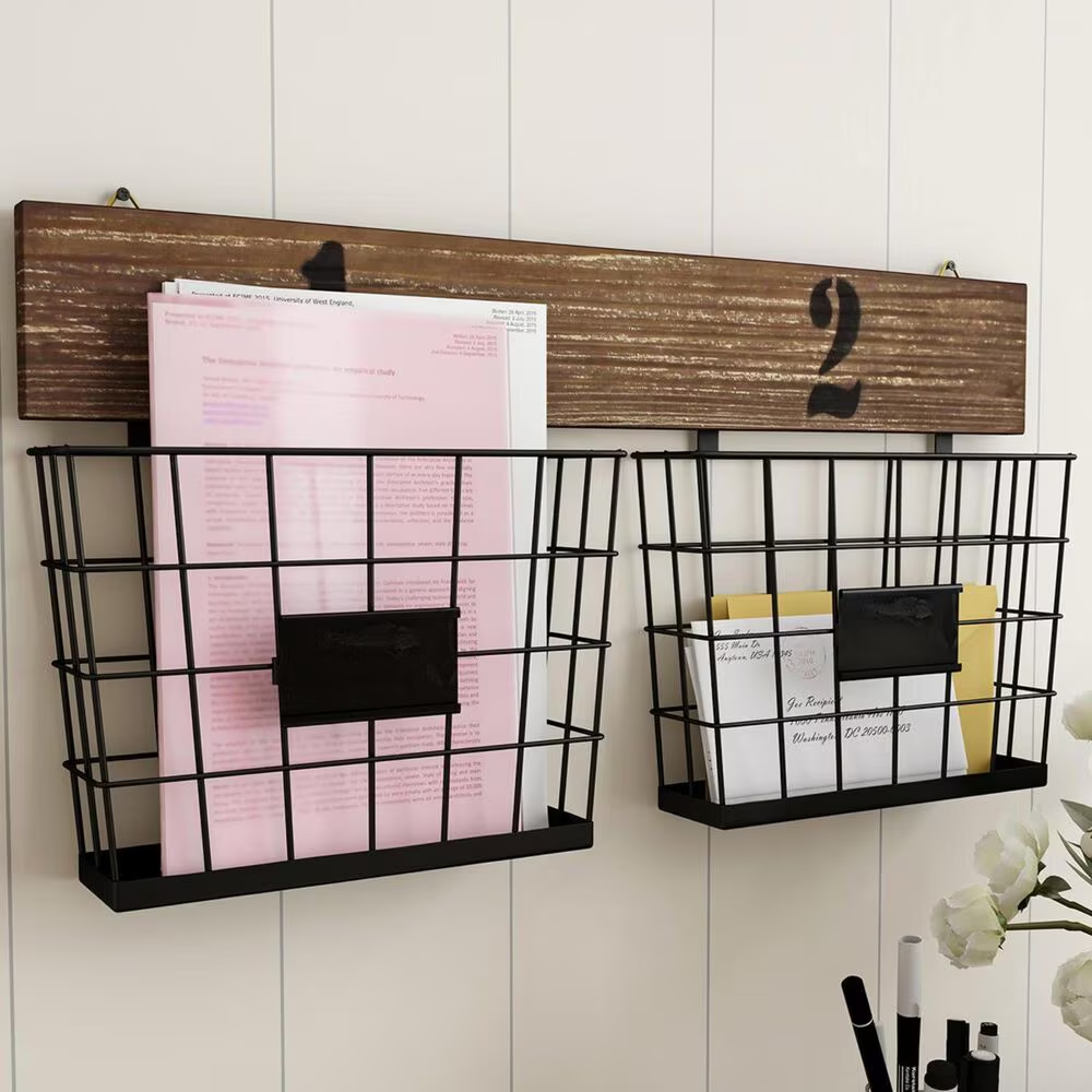 Rustic wall-mounted wire baskets with wood backing for holding letters.