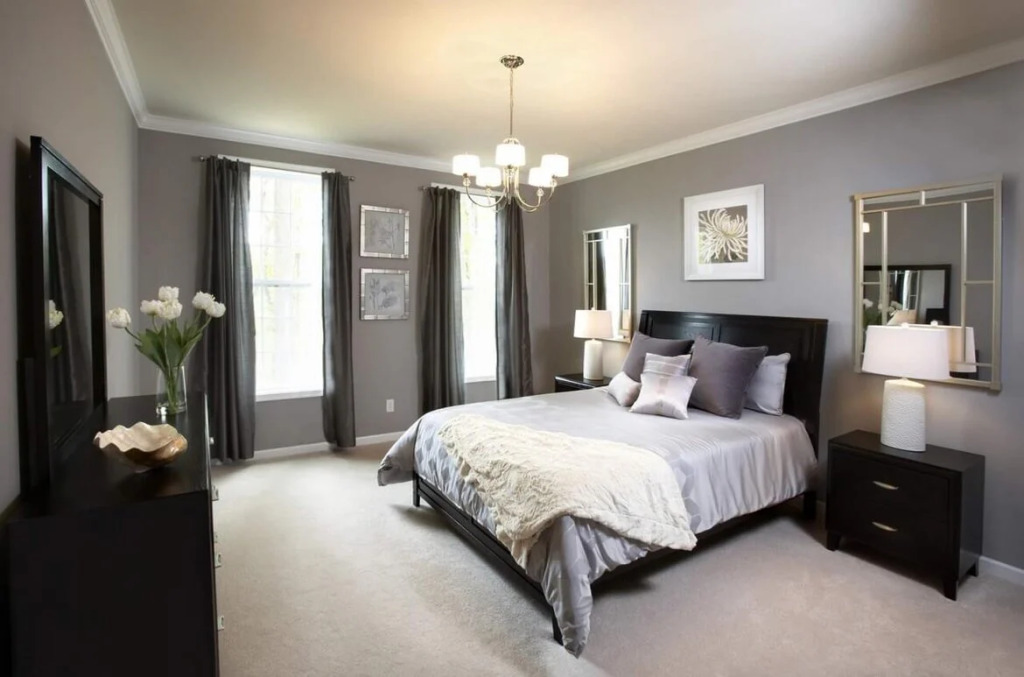 Gray-themed bedroom with dark wood furniture and twin mirrors.