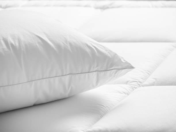 White pillow on soft bedding close-up