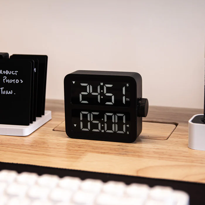 Small digital timer on wooden desk.