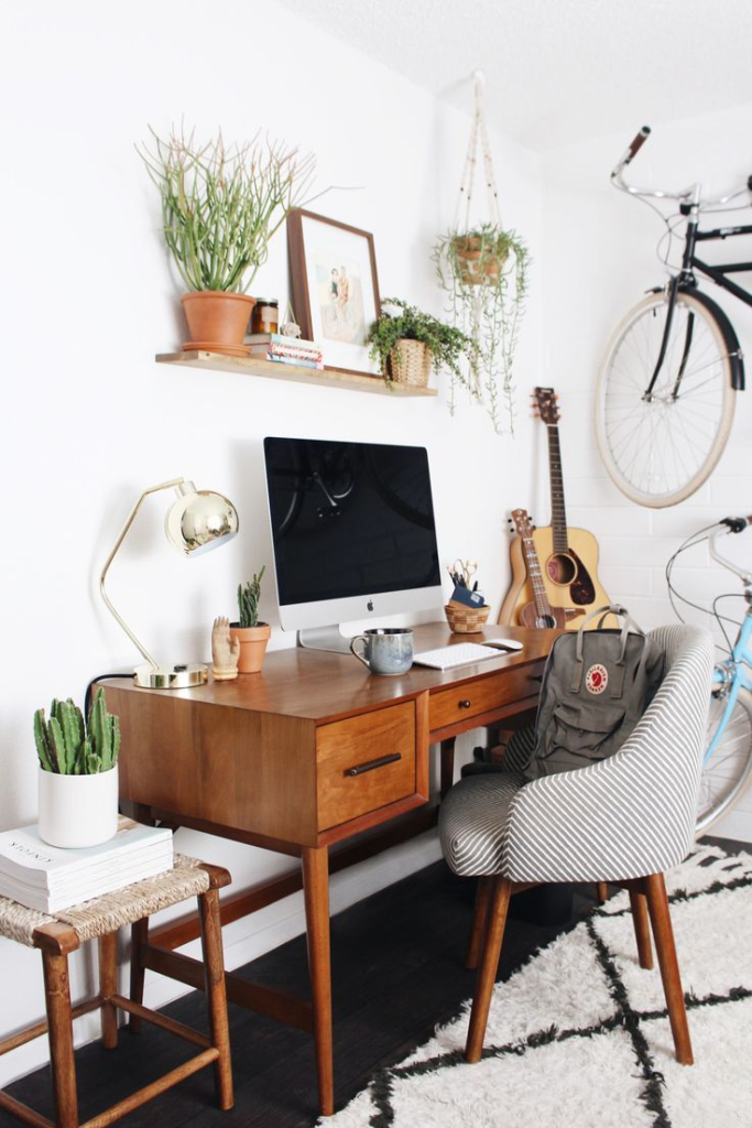 Minimal home office with wood desk and plants.