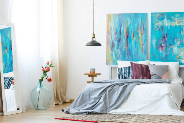 Contemporary bedroom with abstract artwork and layered textiles