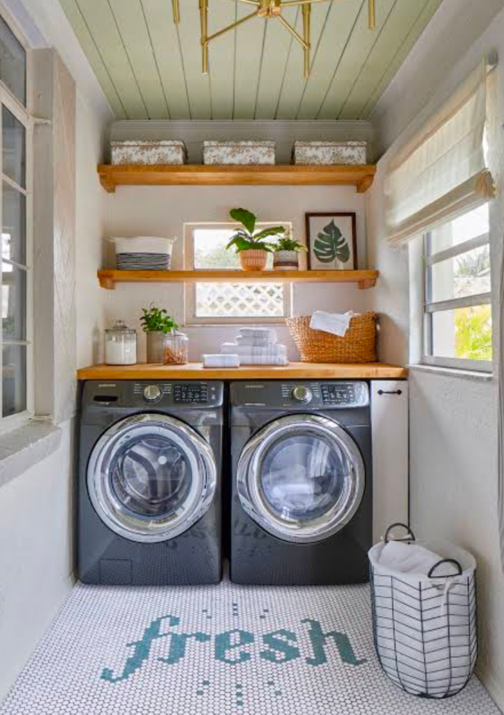 Compact laundry space with wooden shelves and black washers.