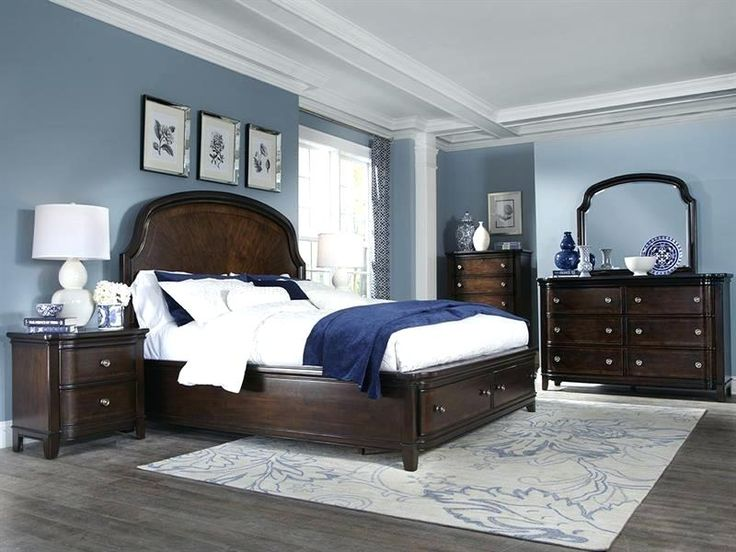 Classic bedroom with blue walls and dark wood furniture.