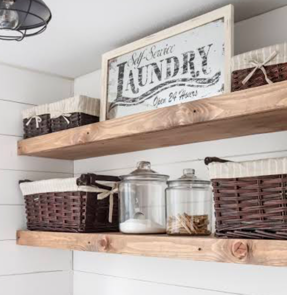 Open wooden laundry shelves with baskets and glass jars.