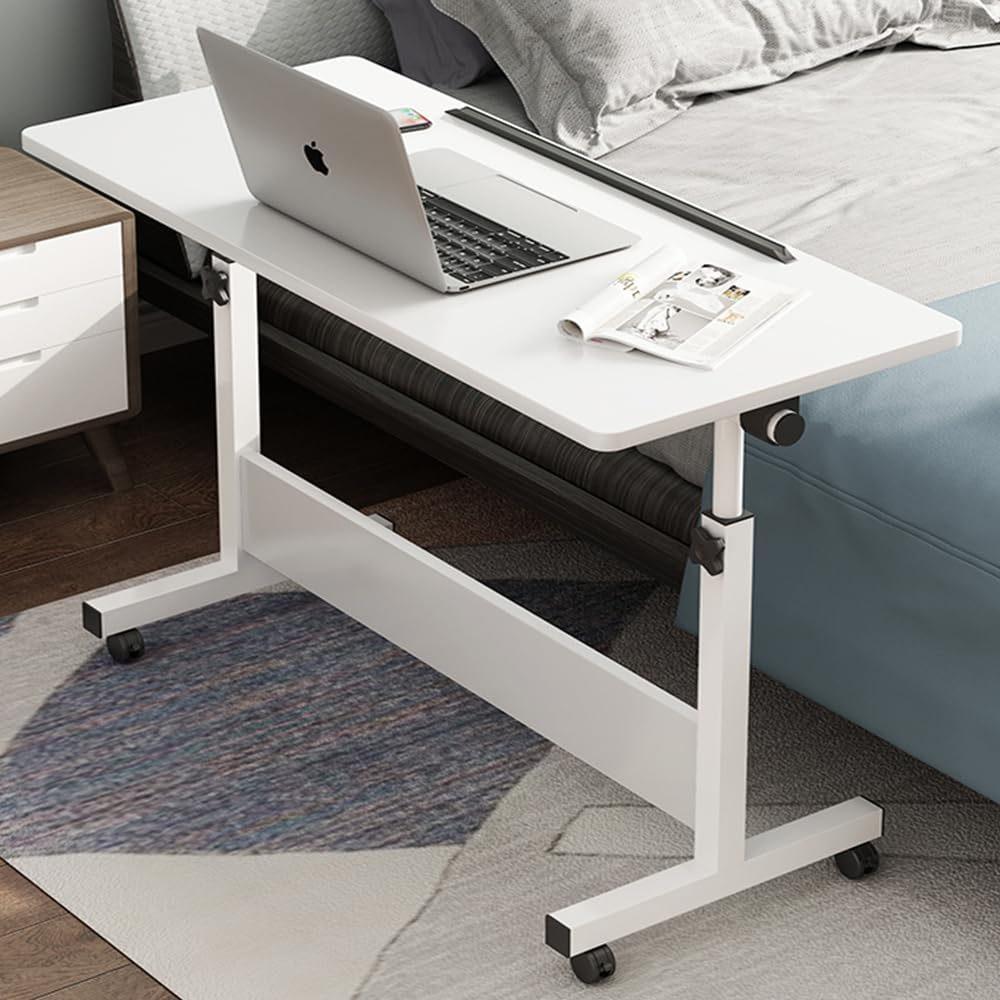Overbed rolling desk in a bedroom setup with a laptop and magazine.