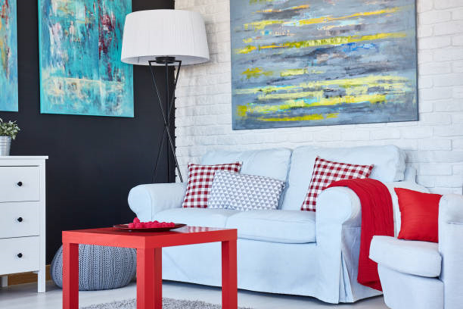 White living room with blue art, red decor