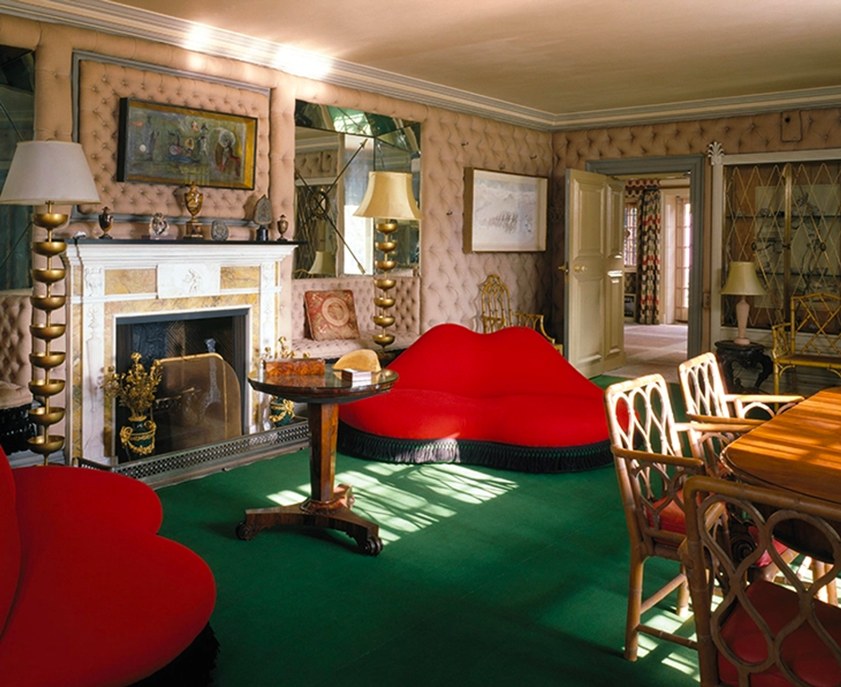 Surrealist living room with red lips sofa, tufted walls and green carpet.
