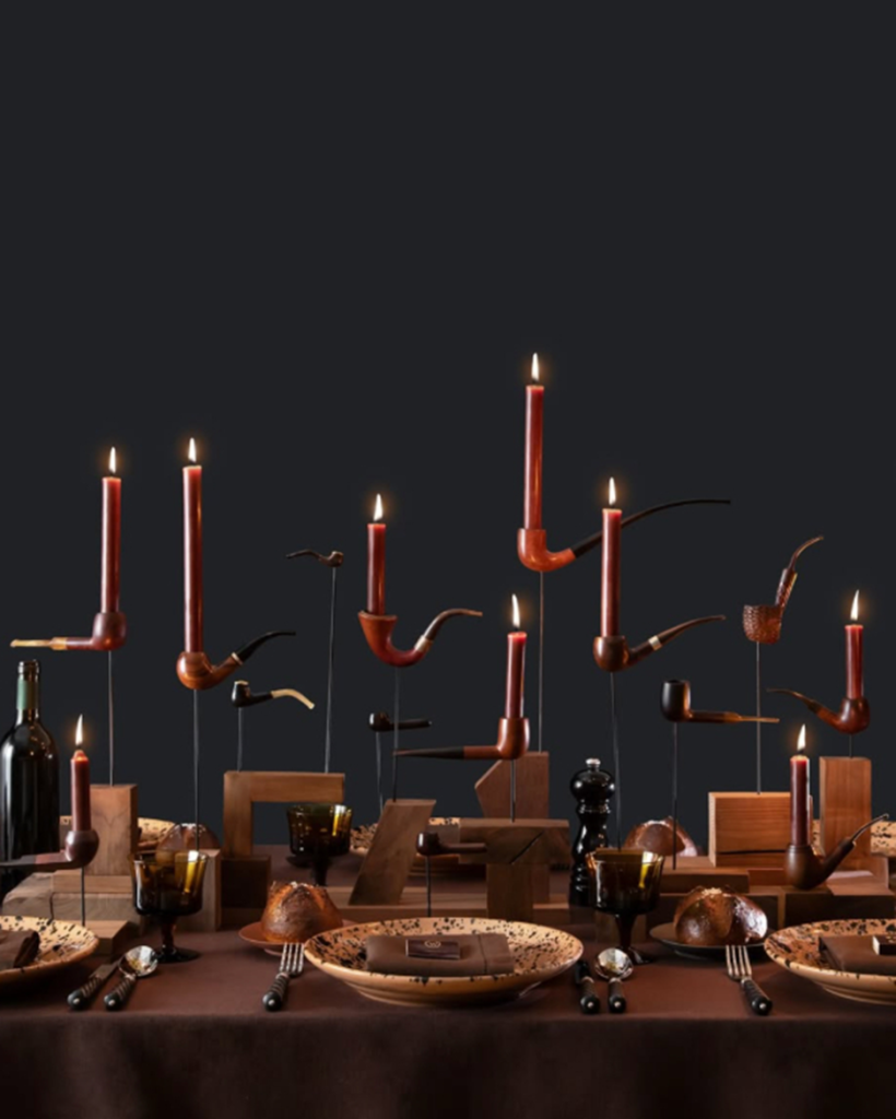 Vintage pipe candle holders on moody dining table.