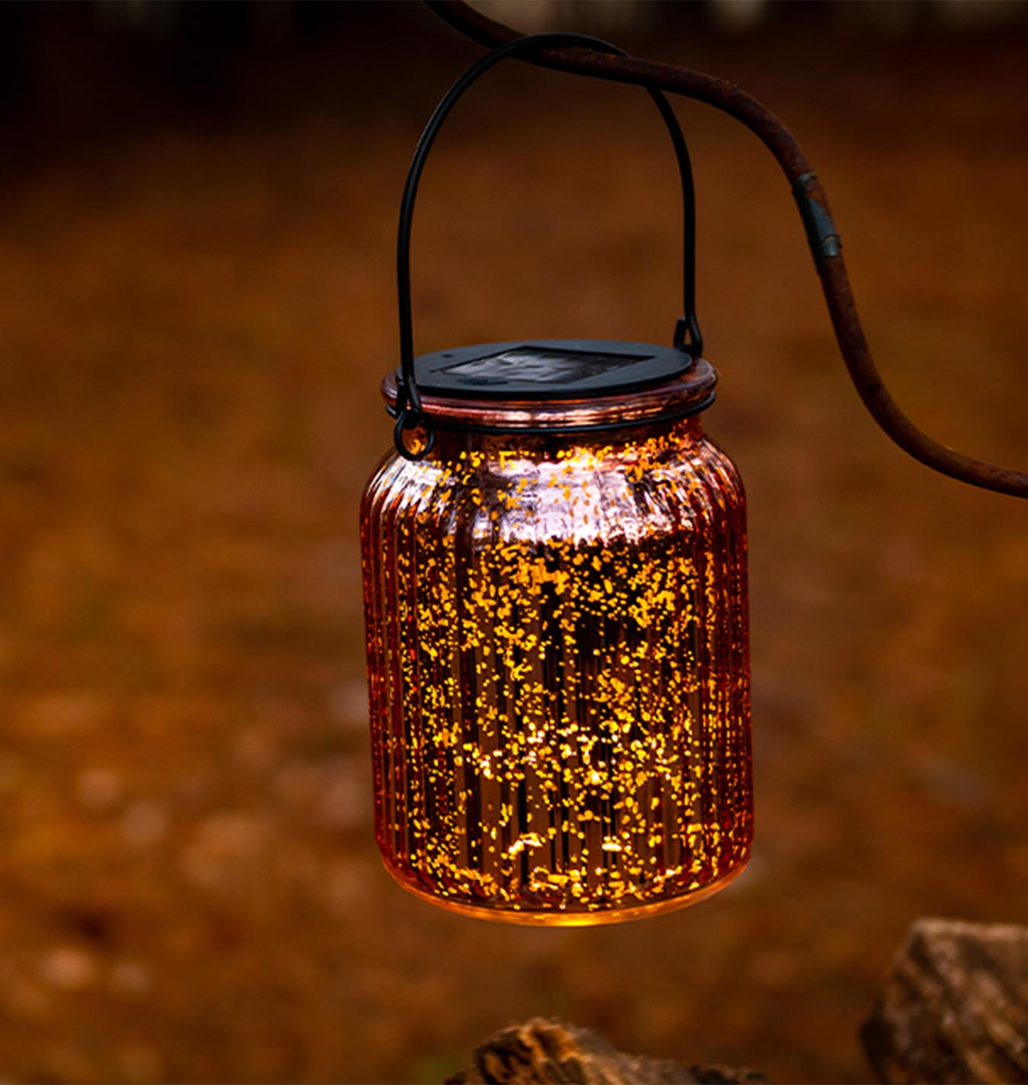 Solar mason jar lantern hanging outdoors, warm ambient garden lighting