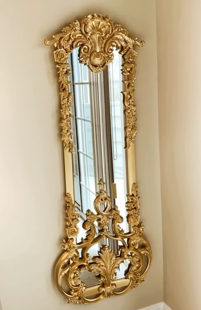 Ornate gold rococo wall mirror with floral scrollwork detail.