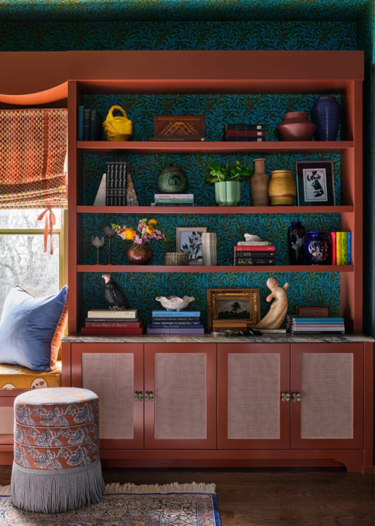 Eclectic styled bookcase with colorful ceramics, books, and art