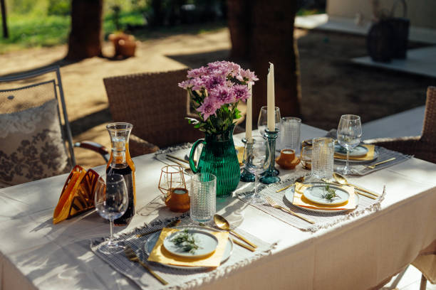 An outdoor table set for a dinner party is ready for guests to arrive