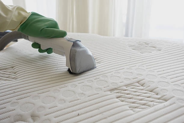 Handheld vacuum cleaning a mattress surface for dust, allergens, and deep sanitation