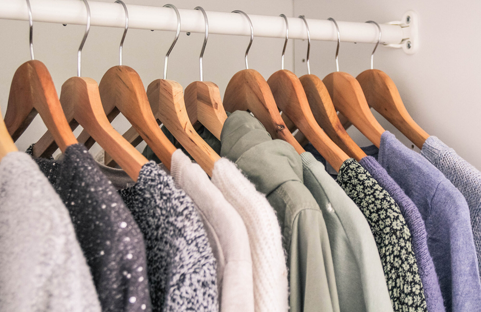 Clothes hanging on wooden hangers for a tidy and well-organized wardrobe