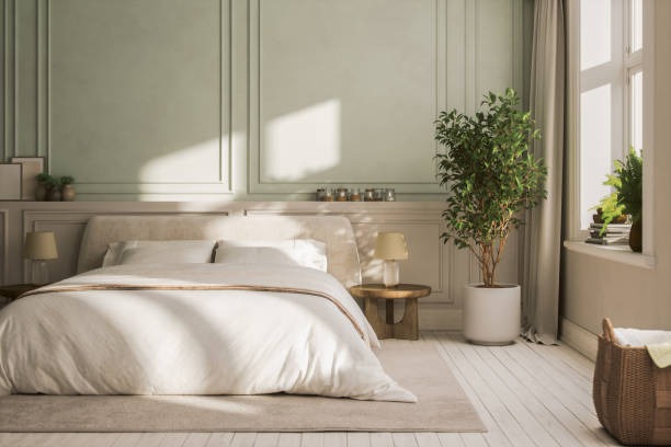Light-filled neutral bedroom with soft bedding, indoor plants, and calming decor.