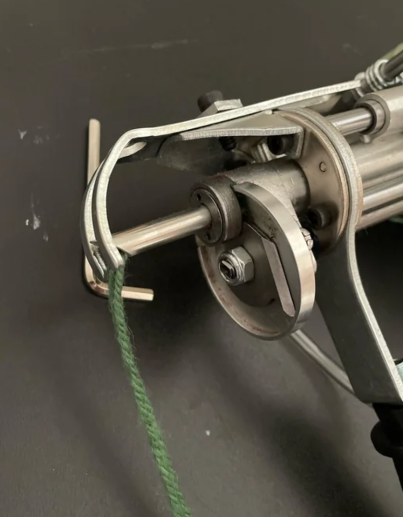 close up of tufting gun threading yarn for making custom handmade rugs and carpets