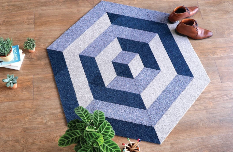 modern geometric hexagon rug in blue tones placed on wooden floor with home decor setup